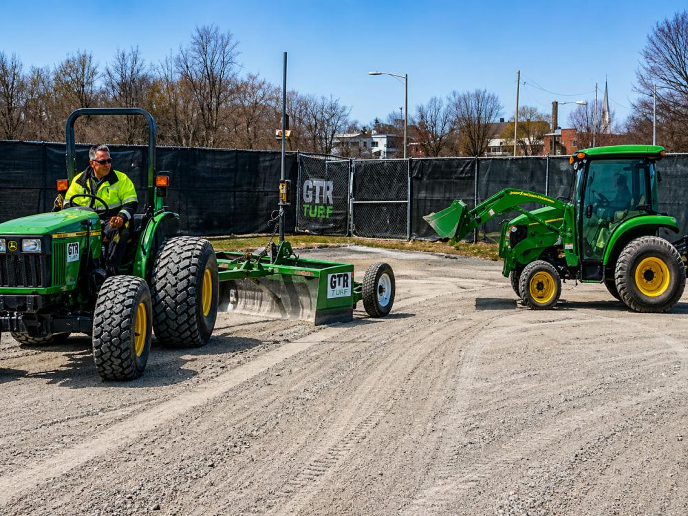 GTR Turf tractors and grading equipment preparing construction site base for synthetic sports field installation.