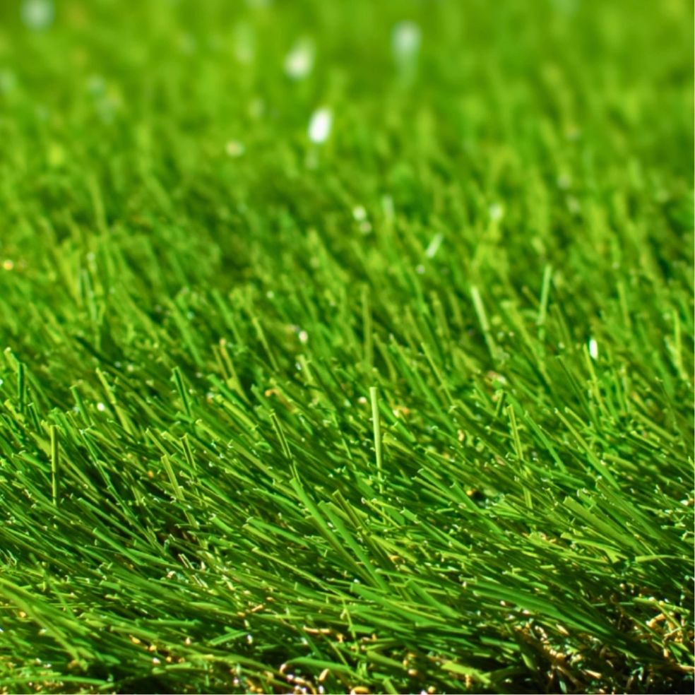 Detailed close-up of vibrant green premium artificial grass blades showing dense turf texture and realistic synthetic lawn surface